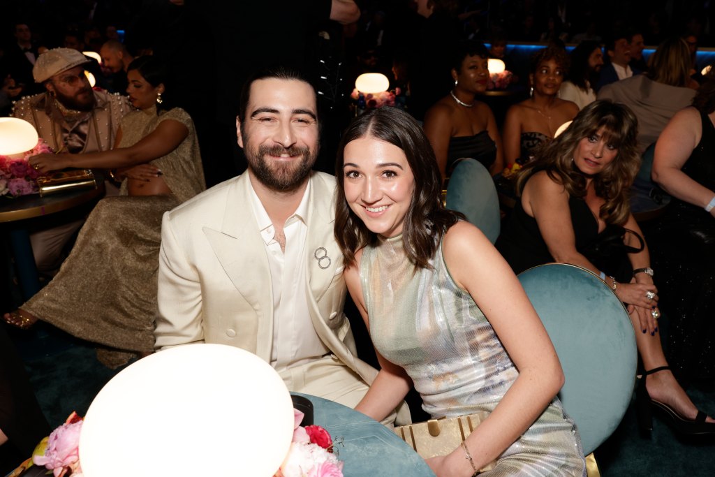 Noah Kahan sits with his wife Brenna Nolan at an awards ceremony.