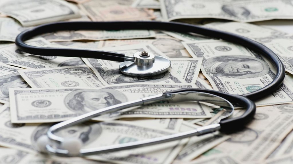 Stethscope on pile of US banknotes