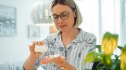 Woman opening a bottle of brain fog supplements