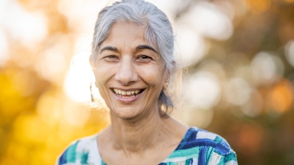 A woman with high cholesterol smiling outdoors