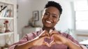 A woman who practices micro-habits making a heart with her hands