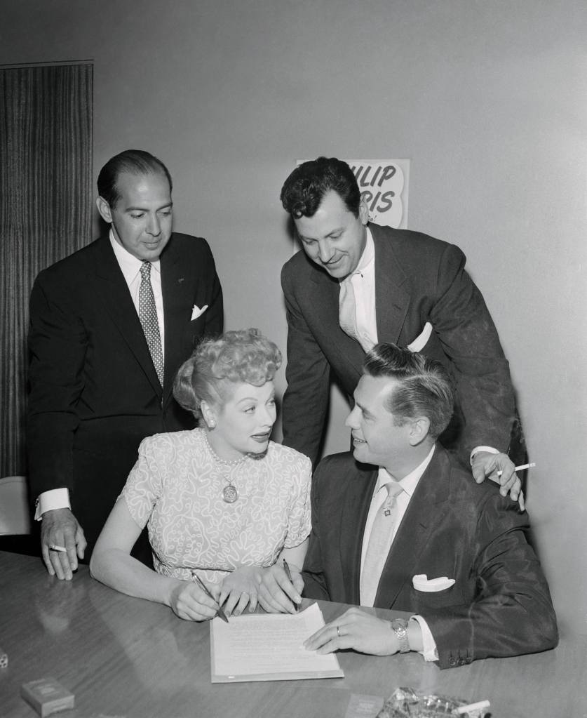 (Original Caption) Lucille Ball and Desi Arnaz, today signed a new $8,000,000 (eight million) contract with Philip Morris Co. and CBS Television which guarantees U.S. televiewers two-and-half years more of "I Love Lucy." In the presence of Harry W. Chesley, Jr., vice president, Philip Morris Co.; Harry Ackerman, CBS-TV Vice President in charge of Network Programs