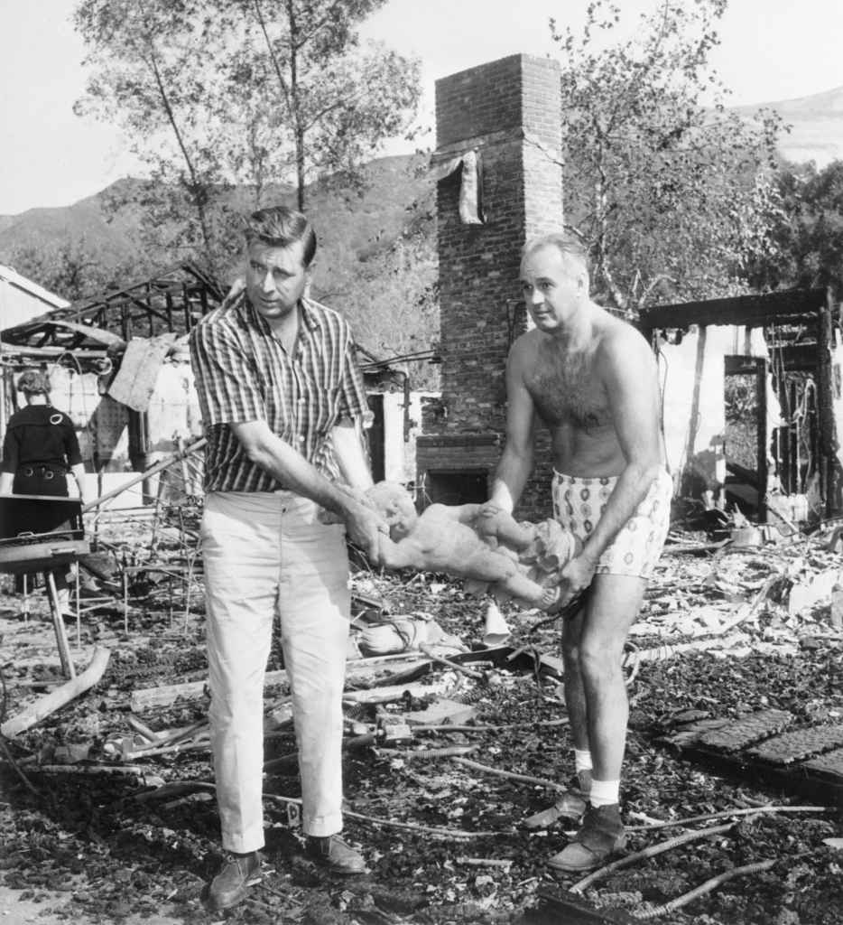(Original Caption) 11/8/1961-Bel Air, CA- Television writer, Gene Roddenberry(left) and attorney, Frank Swann, remove a statue from the burned-out home of TV producer, Leon Benson. The house was one of more than 250 burned in a disastrous brush fire that swept through the area