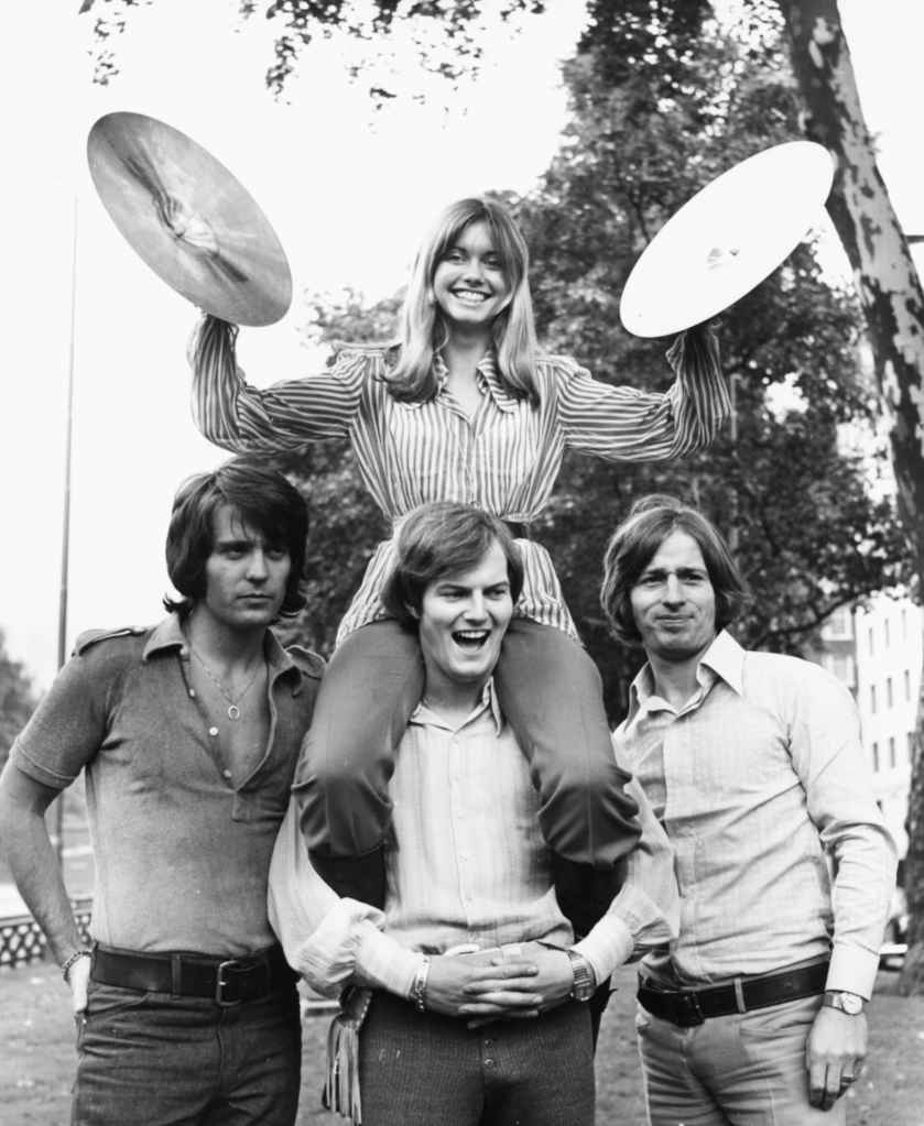 Portrait of singer Olivia Newton John and the band 'Tomorrow'; (L-R) Ben Thomas, Chris Slade and Vic Cooper, at Park Lane, London, August 25th 1970. 