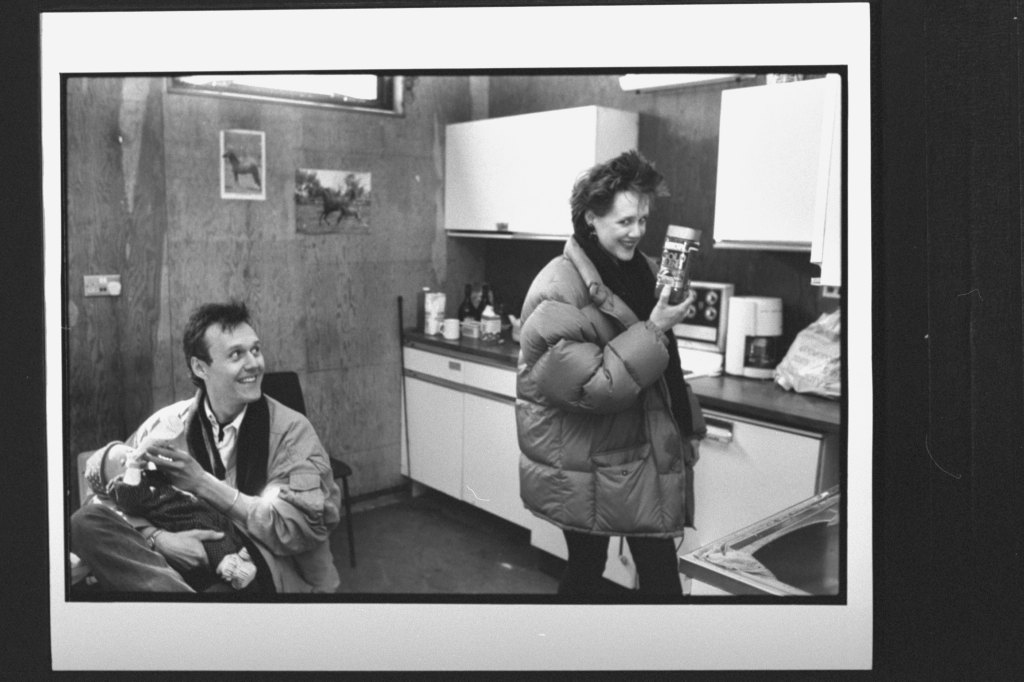 Actor Anthony Head bottle-feeding baby daughter Daisy as live-in lover Sarah Fisher, in down jacket, holds up a jar of Gold Blend coffee, the English version of Taster's Choice; both are made by Nestle's; Head does their popular TV commericals. (Photo by Ian Cook/Getty Images)