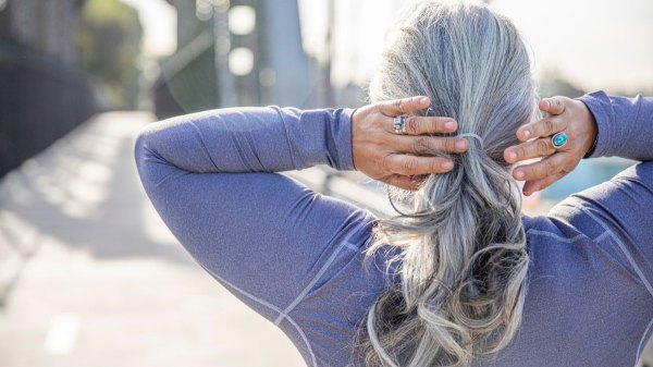 Woman with grey hair touching the back of her hair after trying Traditional Chinese Medicine remedies