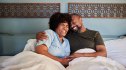 A woman and her partner smiling in bed after trying natural libido boosters