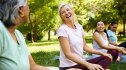 Woman practicing yoga for high blood pressure outdoors while smiling and laughing