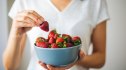 woman holding a bowl of strawberries, one of the best foods to lower A1C