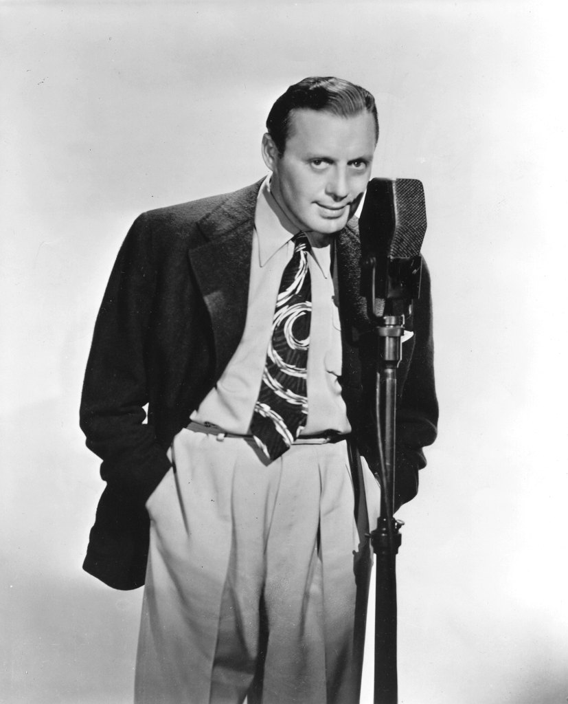 Portrait of actor and comedian Jack Benny standing before a microphone, 1940s.
