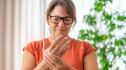 A woman with rheumatoid arthritis touching her wrist