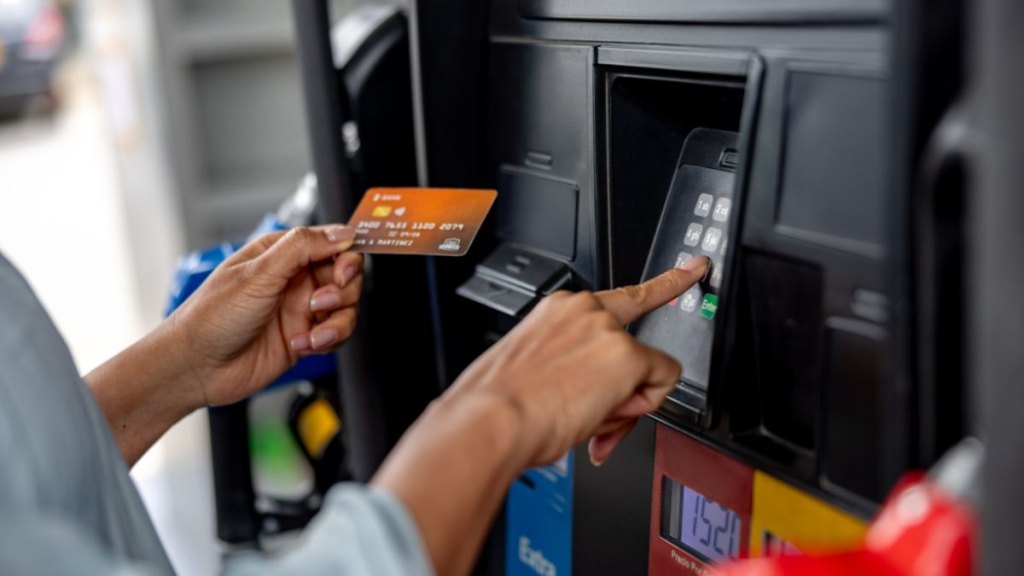 Close-up on a woman paying by card at the gas station