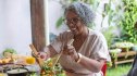 A woman with high blood sugar sitting at a table and serving herself a salad to eat