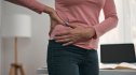 Woman holding her sore hip as if in discomfort