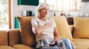 A woman with a dangerous A1C level sitting on a couch with her hand on her chest