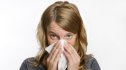 Woman with the flu blowing her nose