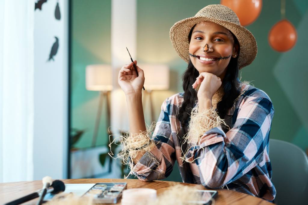 a young woman applying halloween makeup at home