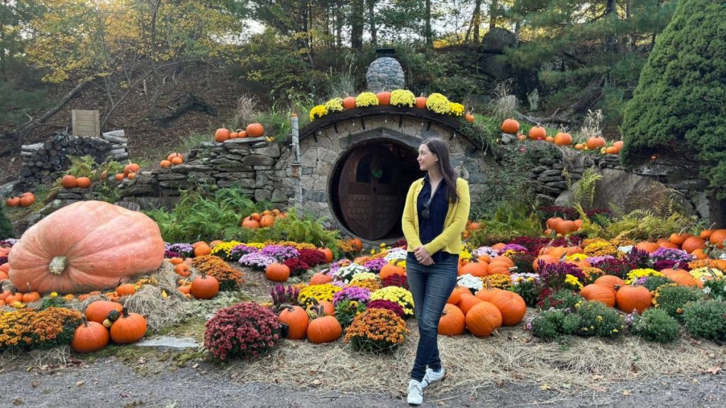 A woman poses in front of the Hobbit House at The Preserve Resort in Rhode Island