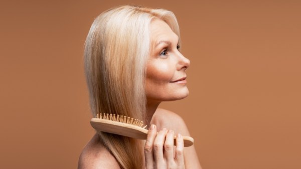 A woman with thinning hair brushing her hair