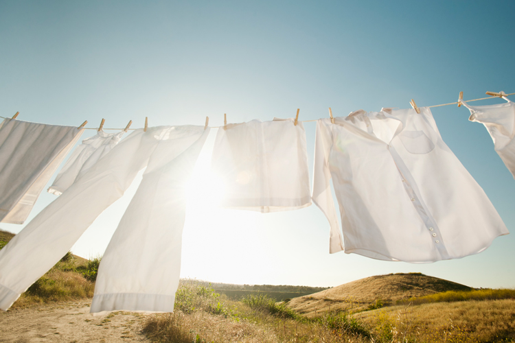 White clothes handing on a clothesline and swaying in the breeze.