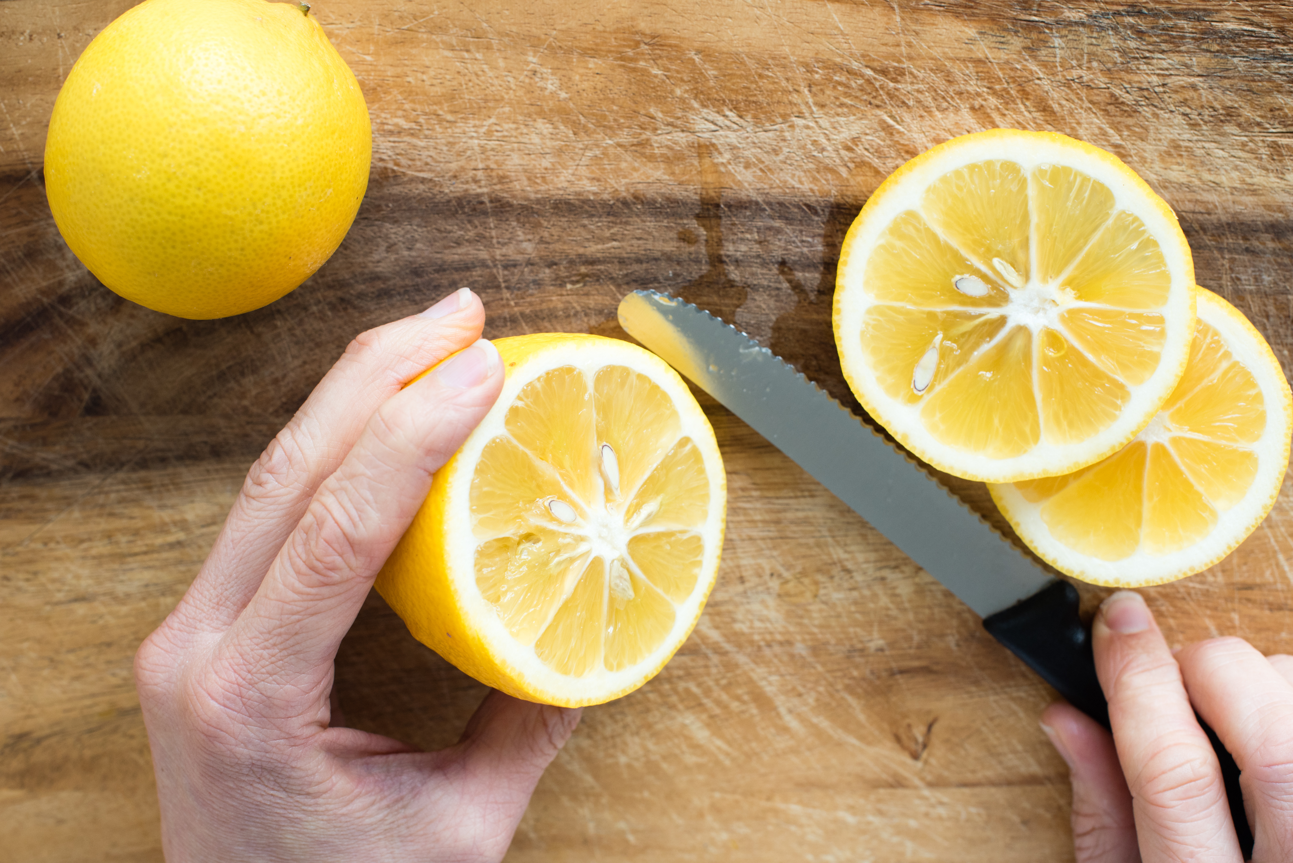 woman cutting lemons on cutting board