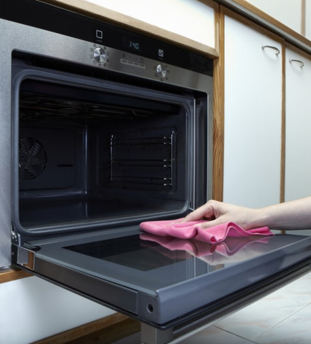 hand cleaning oven with pink washcloth